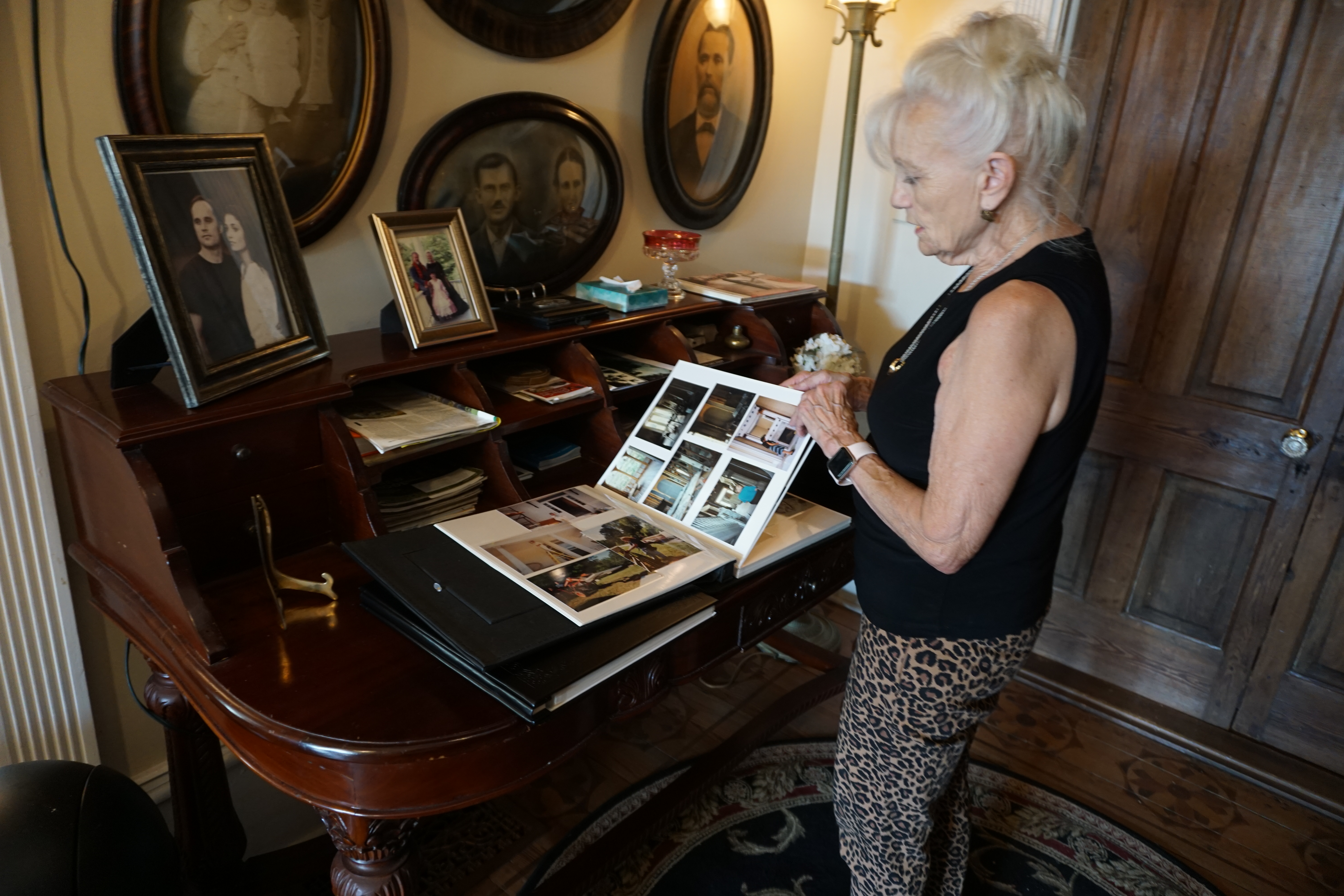 Fair Havens Estate owner Linda Lauderdale looks through binders full of old photos taken during the home’s restoration. This year marks 30 years since her and her late husband bought the once run-down mansion. (Photo/Alex Perri)