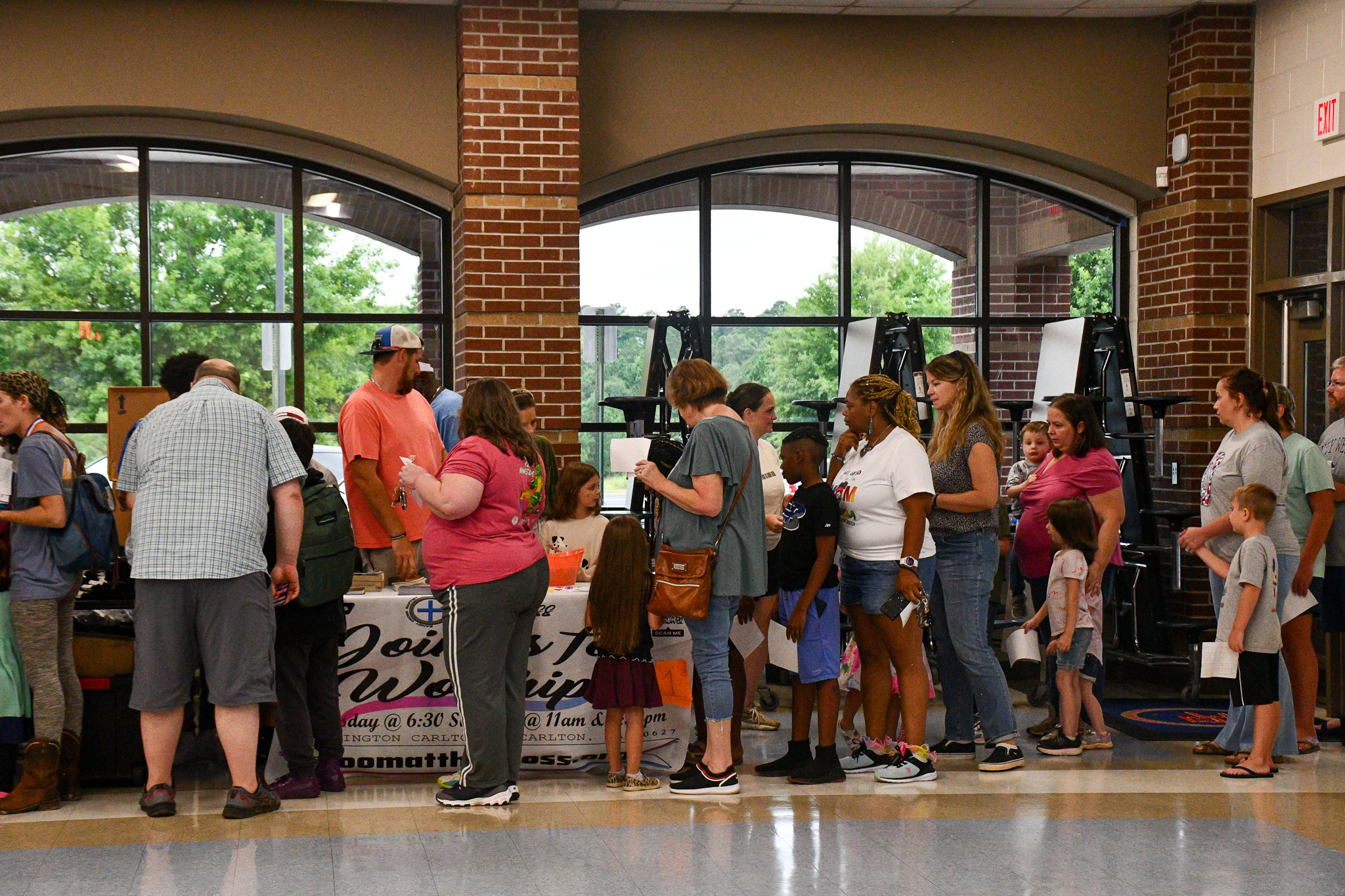 People line up to check out the tables during Community Day at Oglethorpe County Middle School on Saturday. Local organizations passed out free school supplies and resource information to families as students head back to school. (Photo/Jennifer Xia)