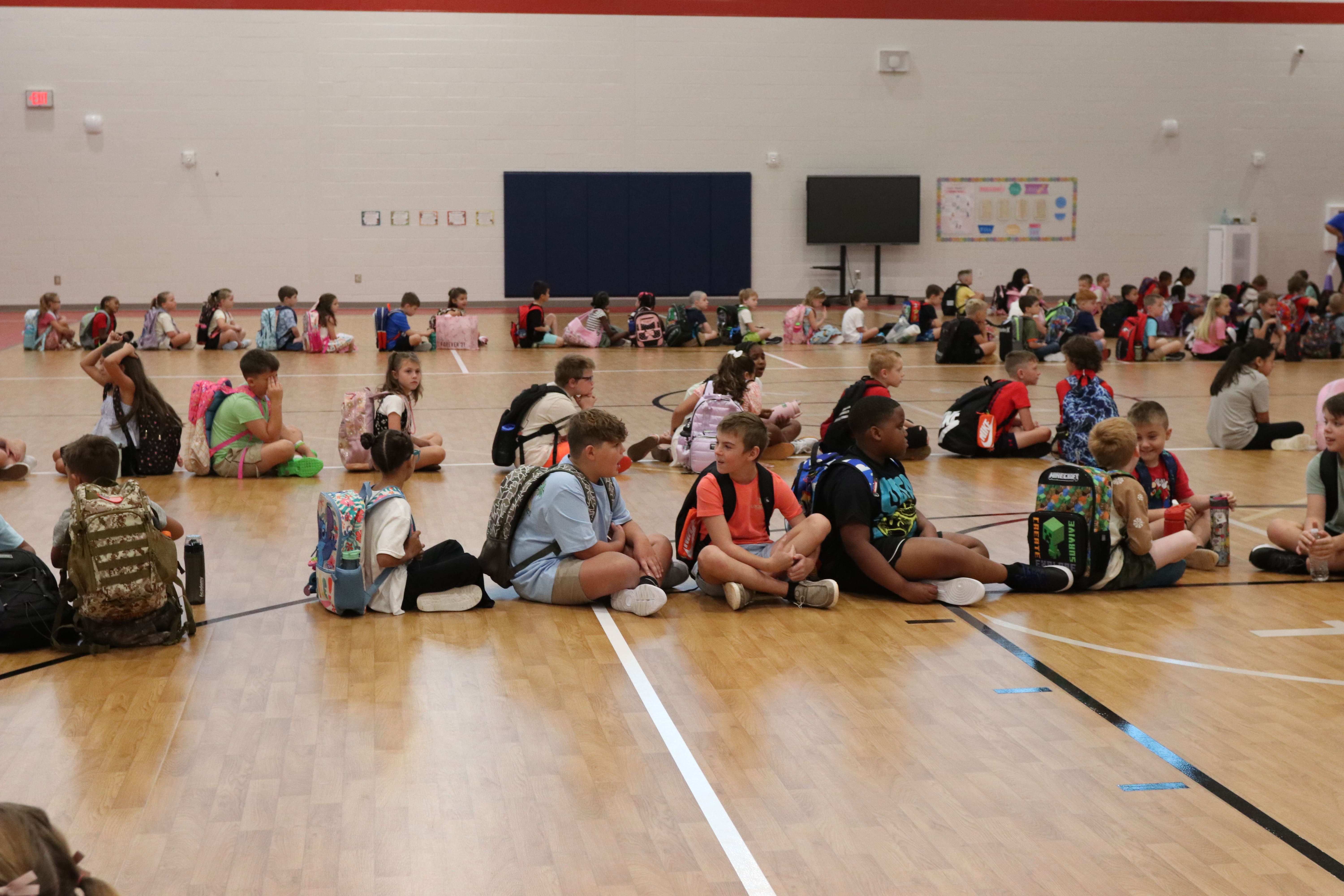 Students in kindergarten through fifth grade sit on the gymnasium floor before walking to home rooms on the first day of school at Oglethorpe County Elementary School. The 2025-26 school year started on Friday in Oglethorpe County. (Photo/Anna Izquierdo)
