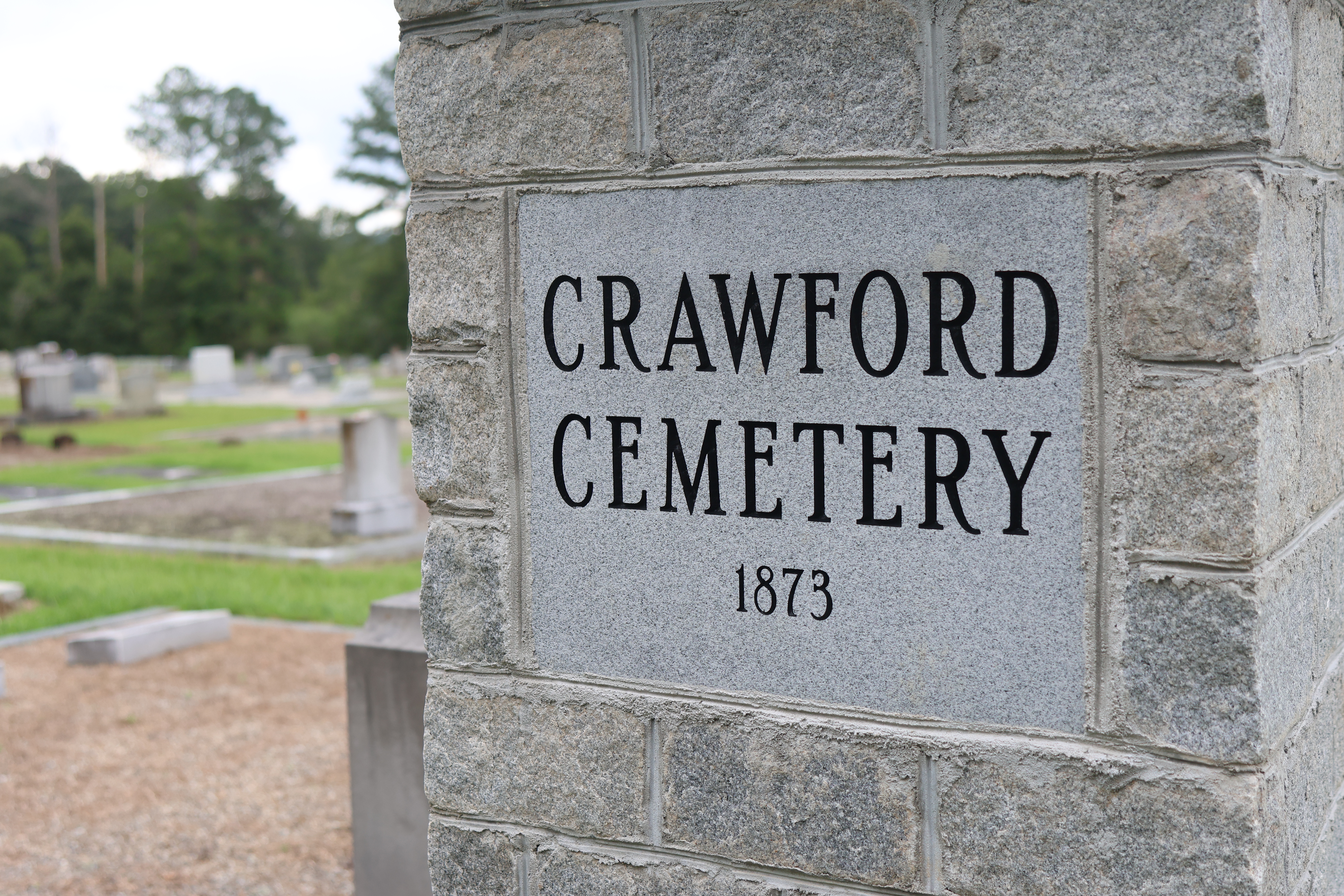 A stone sign marks the entrance of Crawford Cemetery, where the county’s new pauper's plot is located. The county voted in March to buy a plot there. (Katherine Davis/The Oglethorpe Echo)