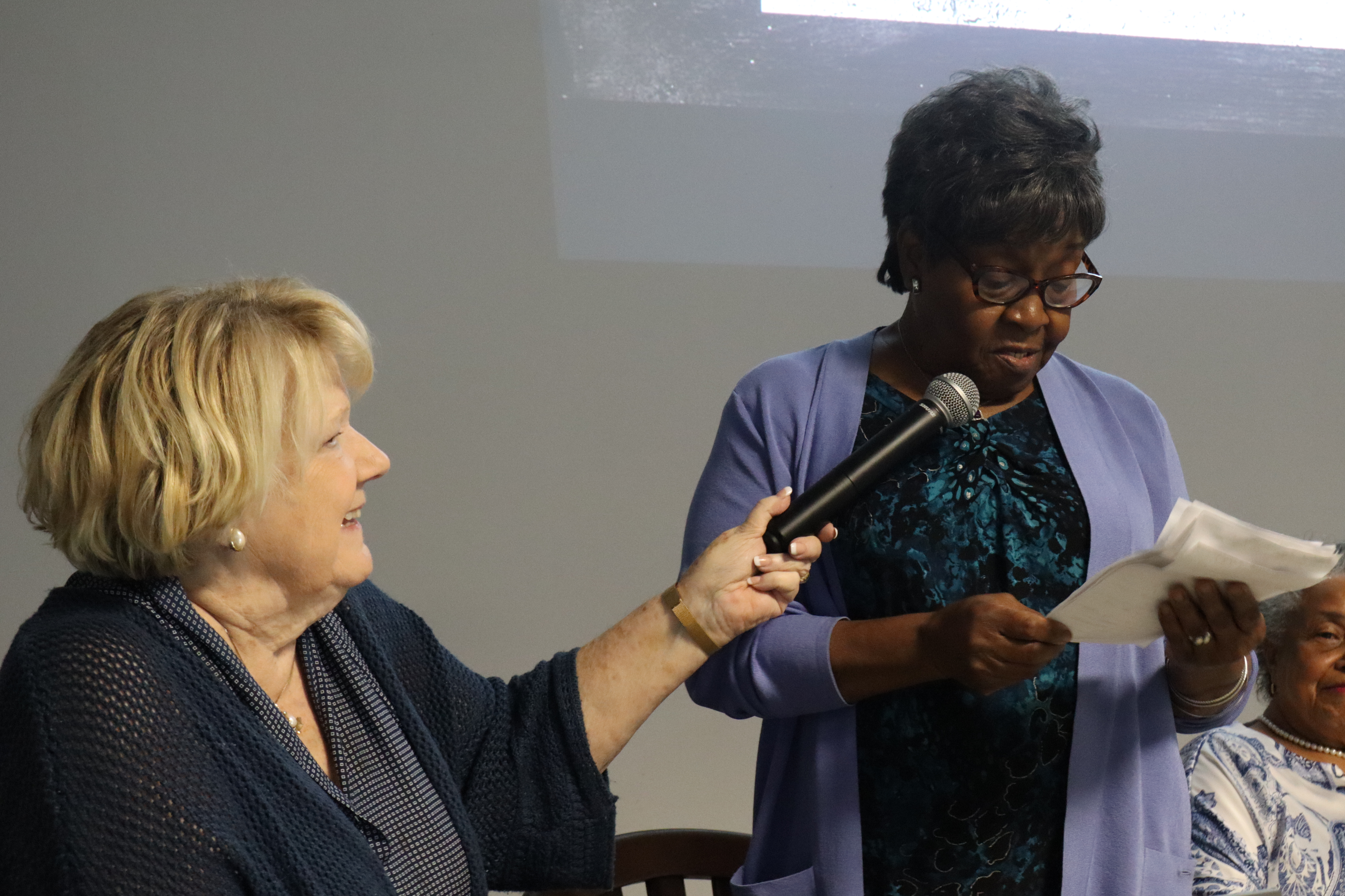 Ashley Simpson holds the mic as Maggie Mobley shares memories from her years at Cedar Grove School, a one-room schoolhouse, during Historic Oglethorpe’s monthly meeting on Tuesday. She recalled how her life changed after the schools were consolidated. (Photo/Molly Moore)