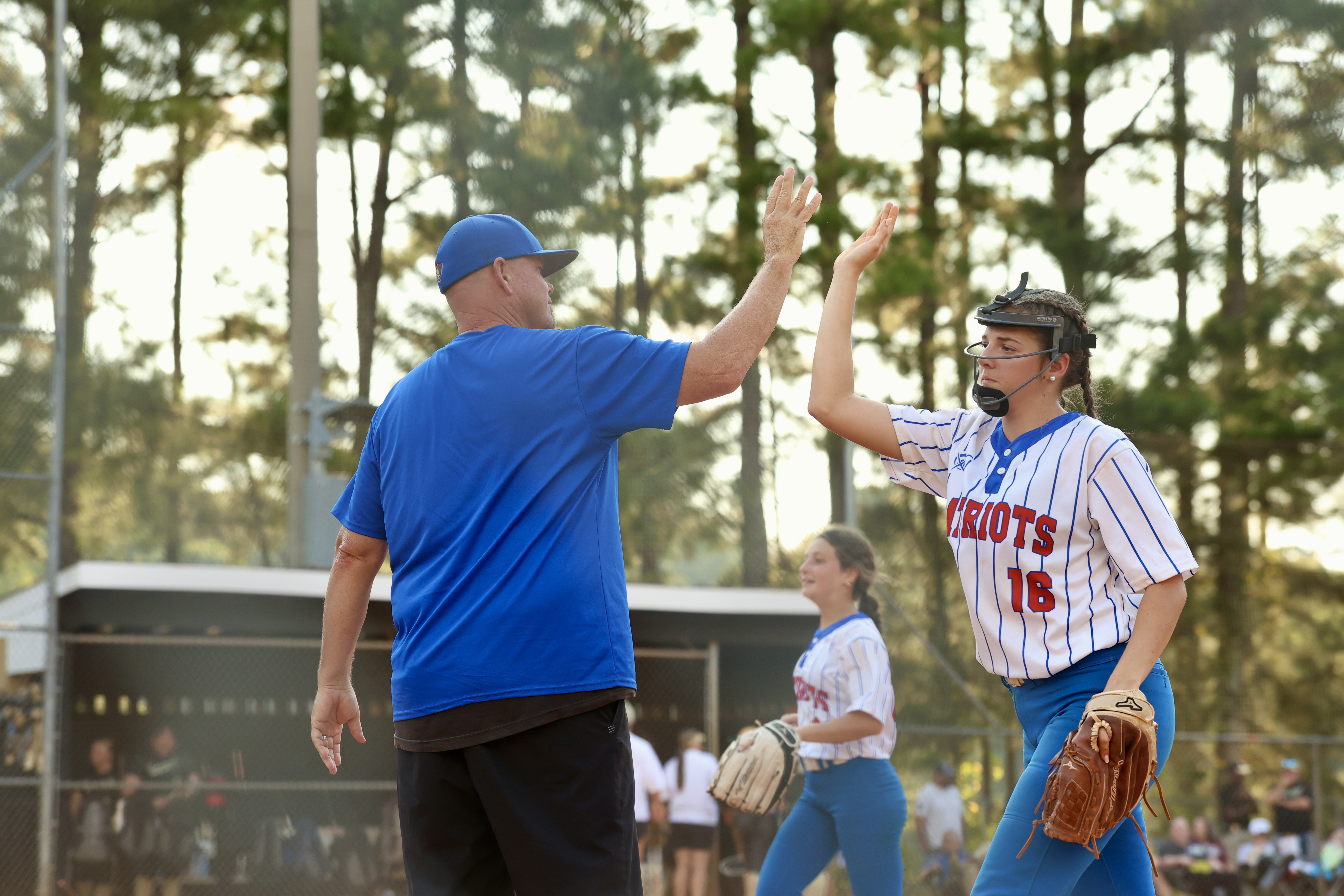 TY JOHNSTON/THE OGLETHORPE ECHO OCHS softball assistant coach Mike Campbell high-fives Lillie Anderson during the Patriots’ 10-2 win over Commerce on Tuesday. Anderson had two hits and an RBI as part of the 15-hit attack.