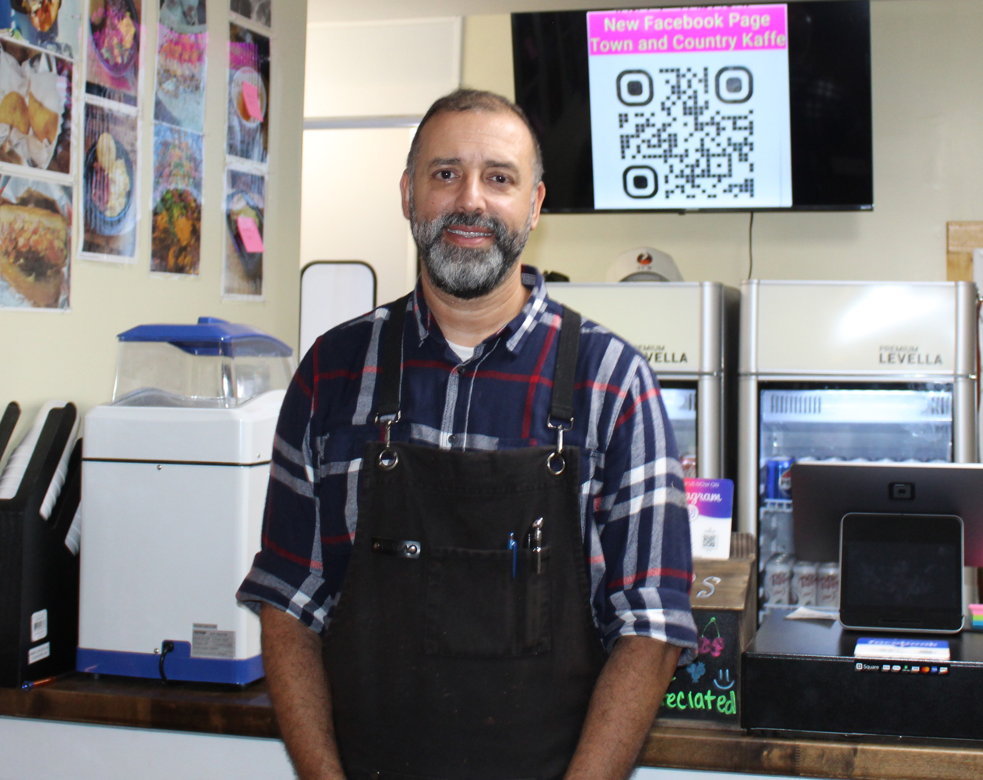 Willie Torres stands in front of the counter of his restaurant, Town and Country Kafe, that he co-owns with his wife, Amy Delfin-Torres. The couple decided to put the restaurant on the market after three years to pursue other personal opportunities like traveling. (photo/Emily Adams)