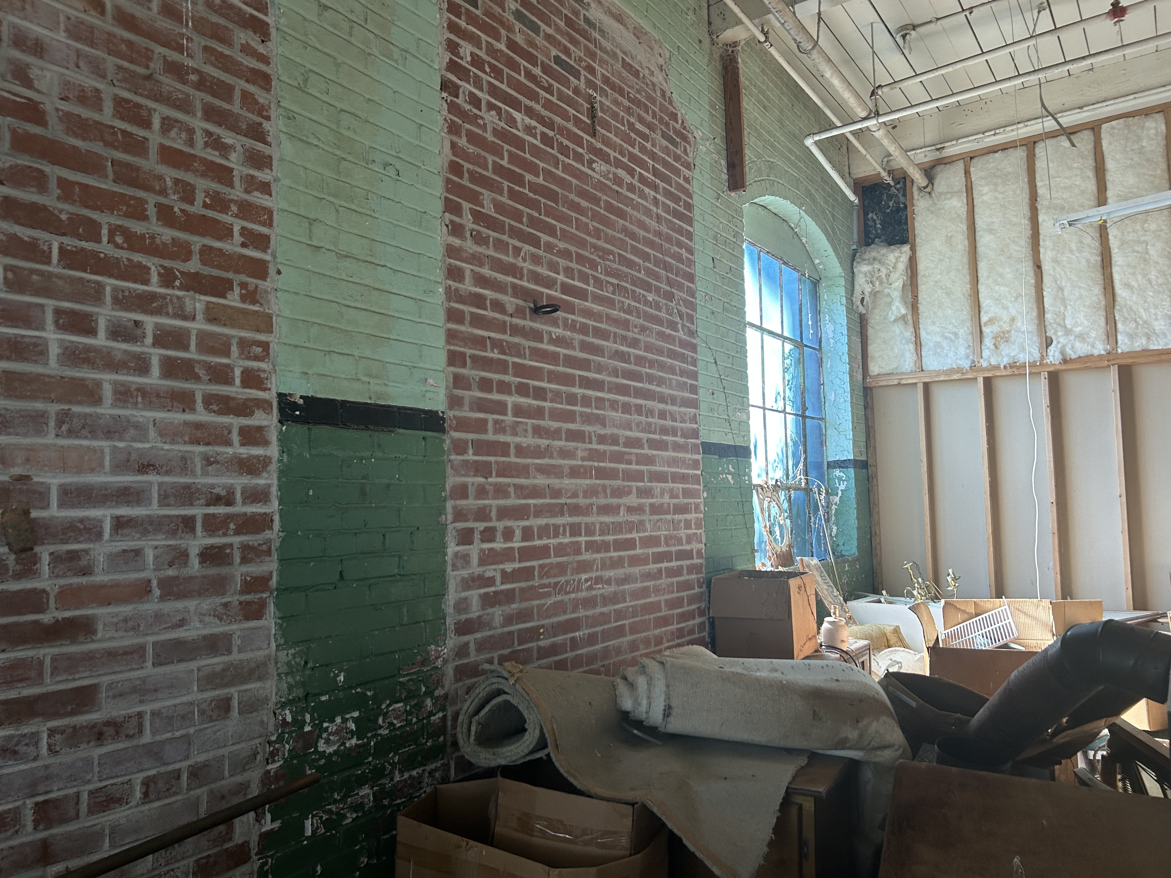 The upstairs of the factory building was partially insulated for an apartment, and part of it has exposed brick walls and large windows. This is part of the Historic Jefferson Mill property in Crawford that went up for sale in October of 2025 for $1.6 million. (Makenna Reavis/The Oglethorpe Echo)