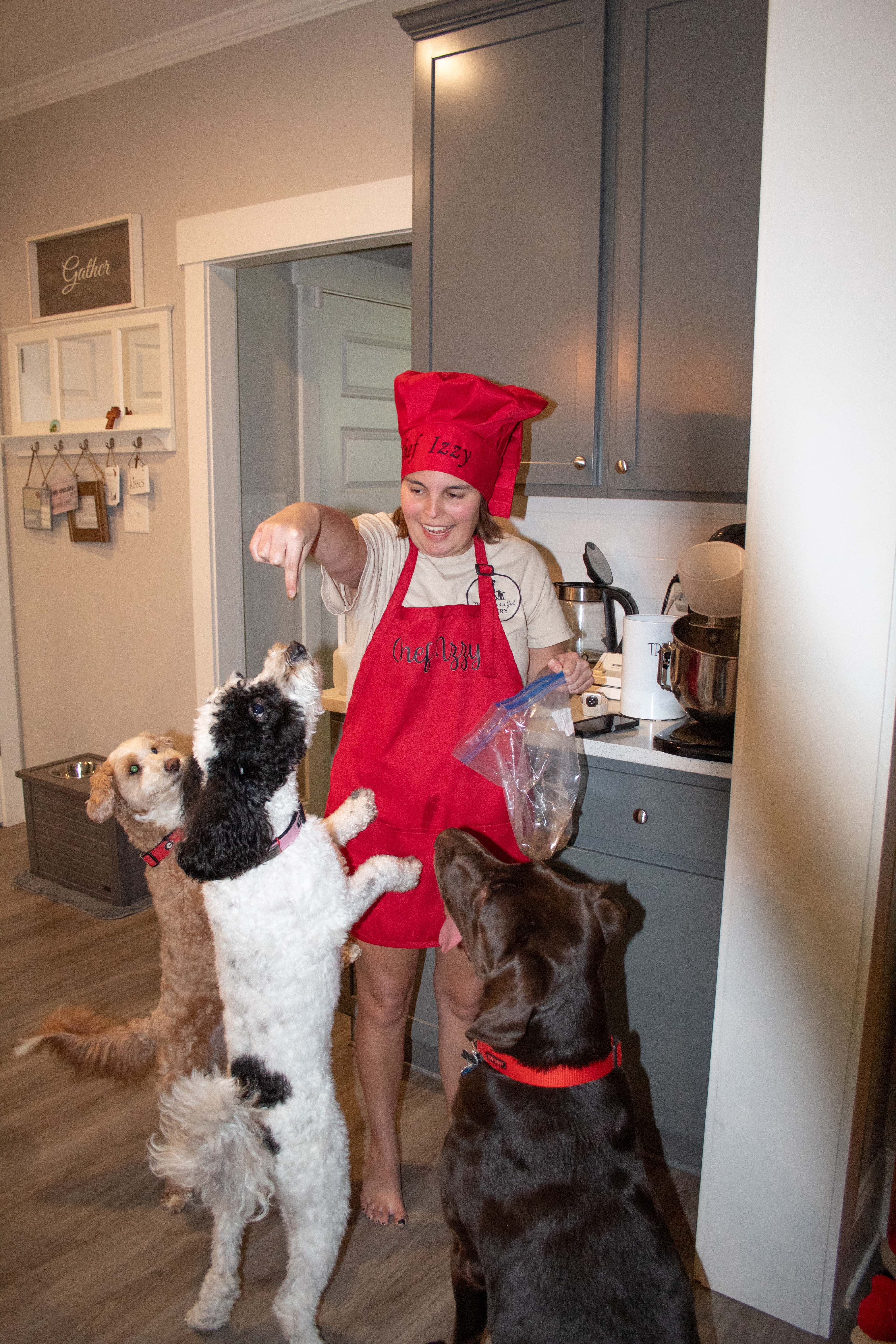 Izzy Marler tempts Axel, Savannah and Riley with treats made just for them in the kitchen that serves as the home for Three Dogs and a Girl Bakery. Dog treats are Marler’s favorite products to make. (Grace Burnett/The Oglethorpe Echo)