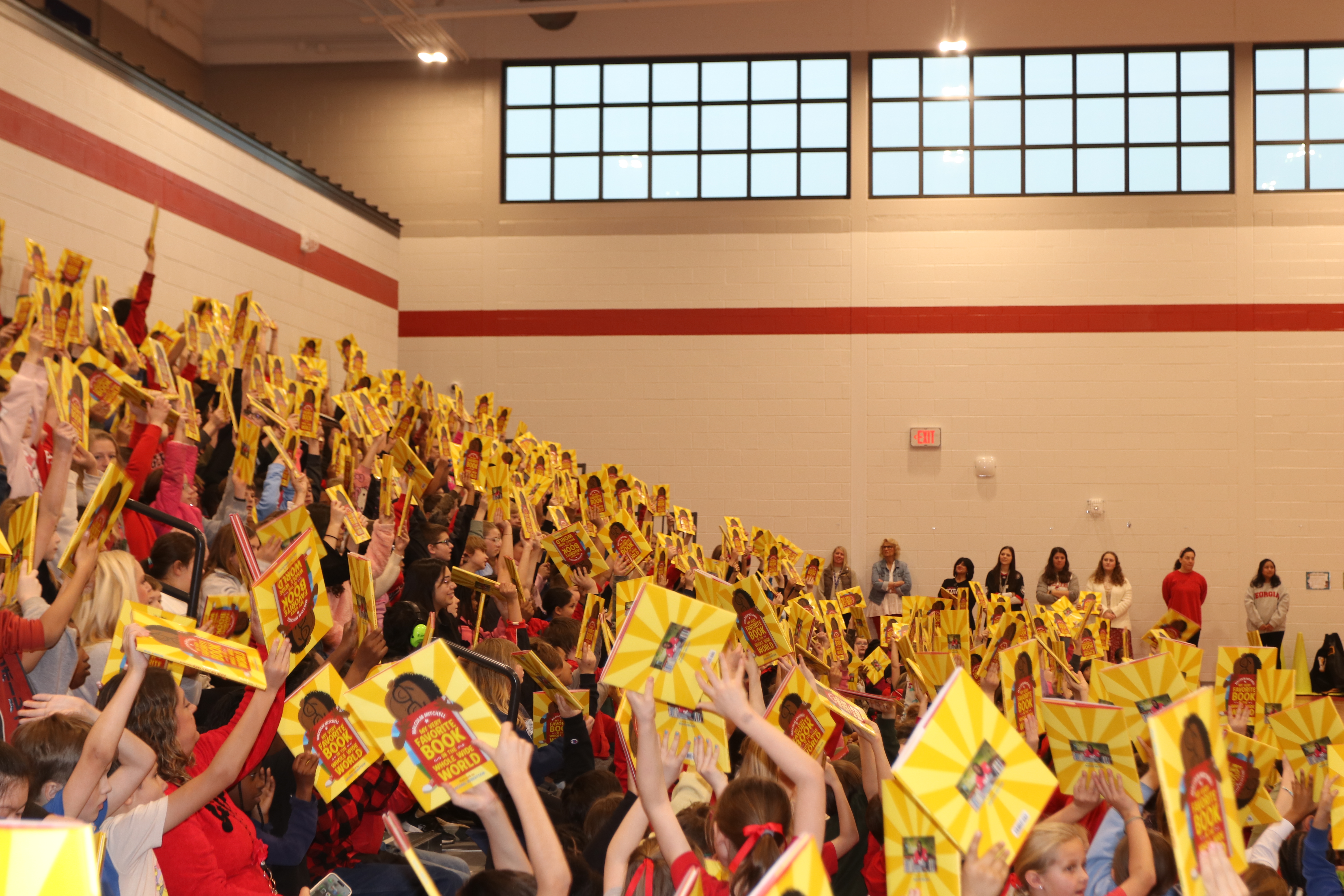 Students at the OCES Reading Rally hold up their copies of “My Very Favorite Book in the Whole Wide World” by Malcolm Mitchell. Every student received a copy of the book prior to the celebration of World Read Aloud Day. (CHARLOTTE COCHRAN/THE OGLETHORPE ECHO)