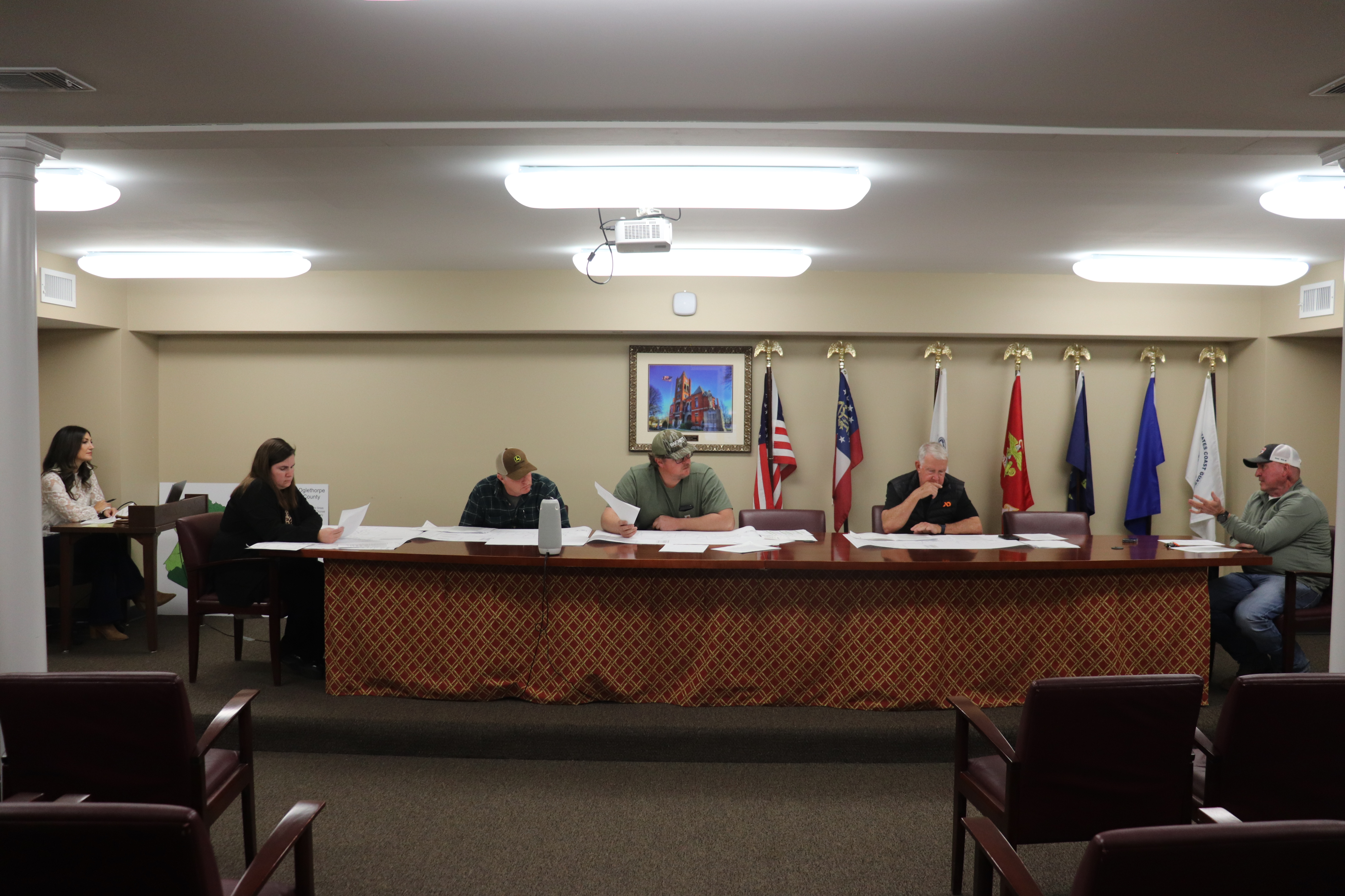 From left, Morgan Robinson, Sam Nash, JF Hansford, Jimmy Shealy and Chair Janet Hill, who joined by Zoom, attend the Feb. 12 zoning board meeting. At the end of the table is Jeff Sharp, director of planning, zoning and compliance. Teresa Campbell, planning assistant and permitting administrator, sits at the desk on the far left taking meeting minutes. One of the approved items by the board was a variance to acreage rules requested by William Cunningham. (Photo Emilie Sullivan/The Oglethorpe Echo)
