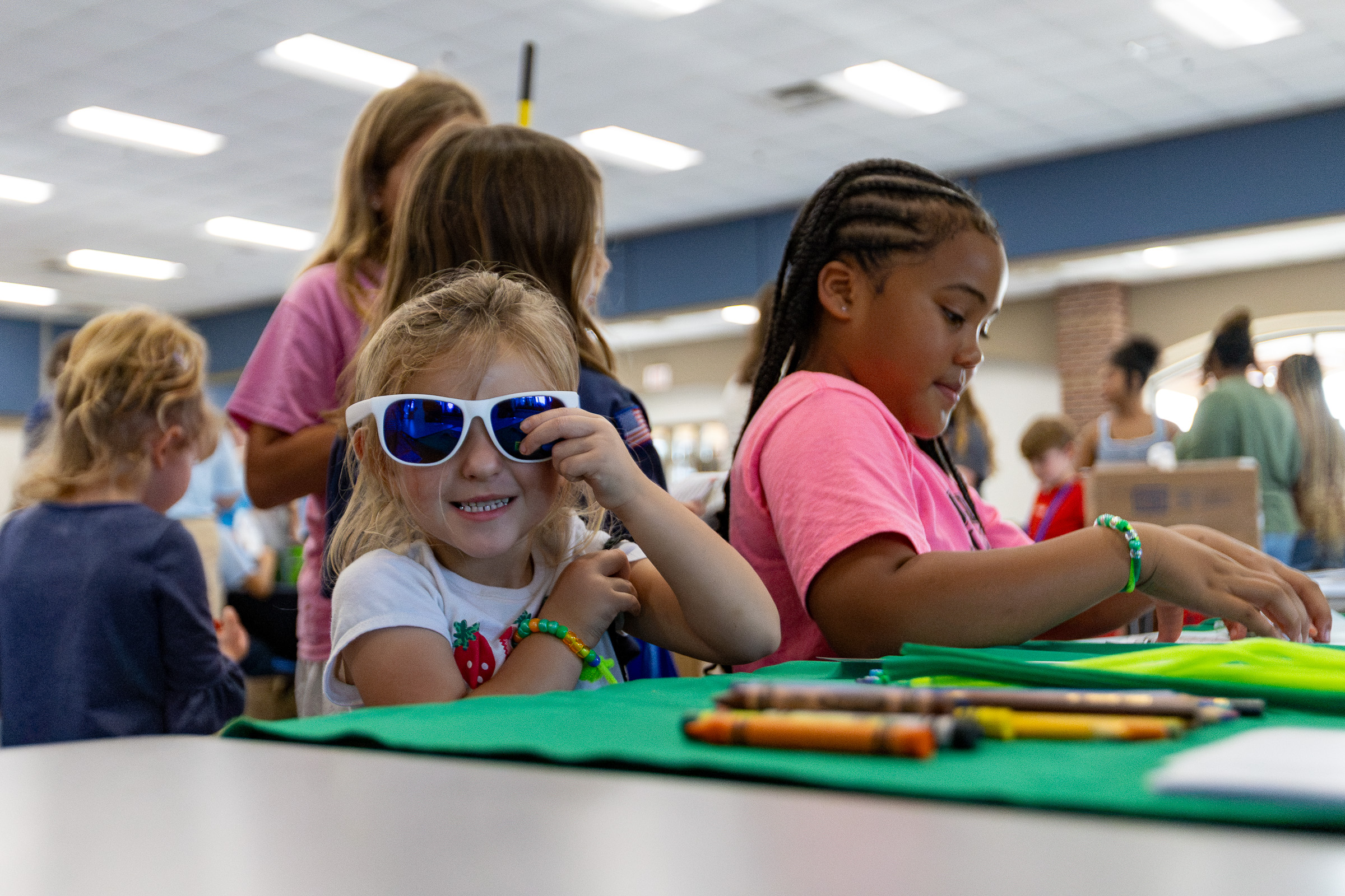 Samantha Mathe tries on new sunglasses at Community Day. Most of the handouts involved the theme of hygiene and included deodorant, dental floss, hairbrushes, soap and socks. (Ethan Greene/The Oglethorpe Echo)