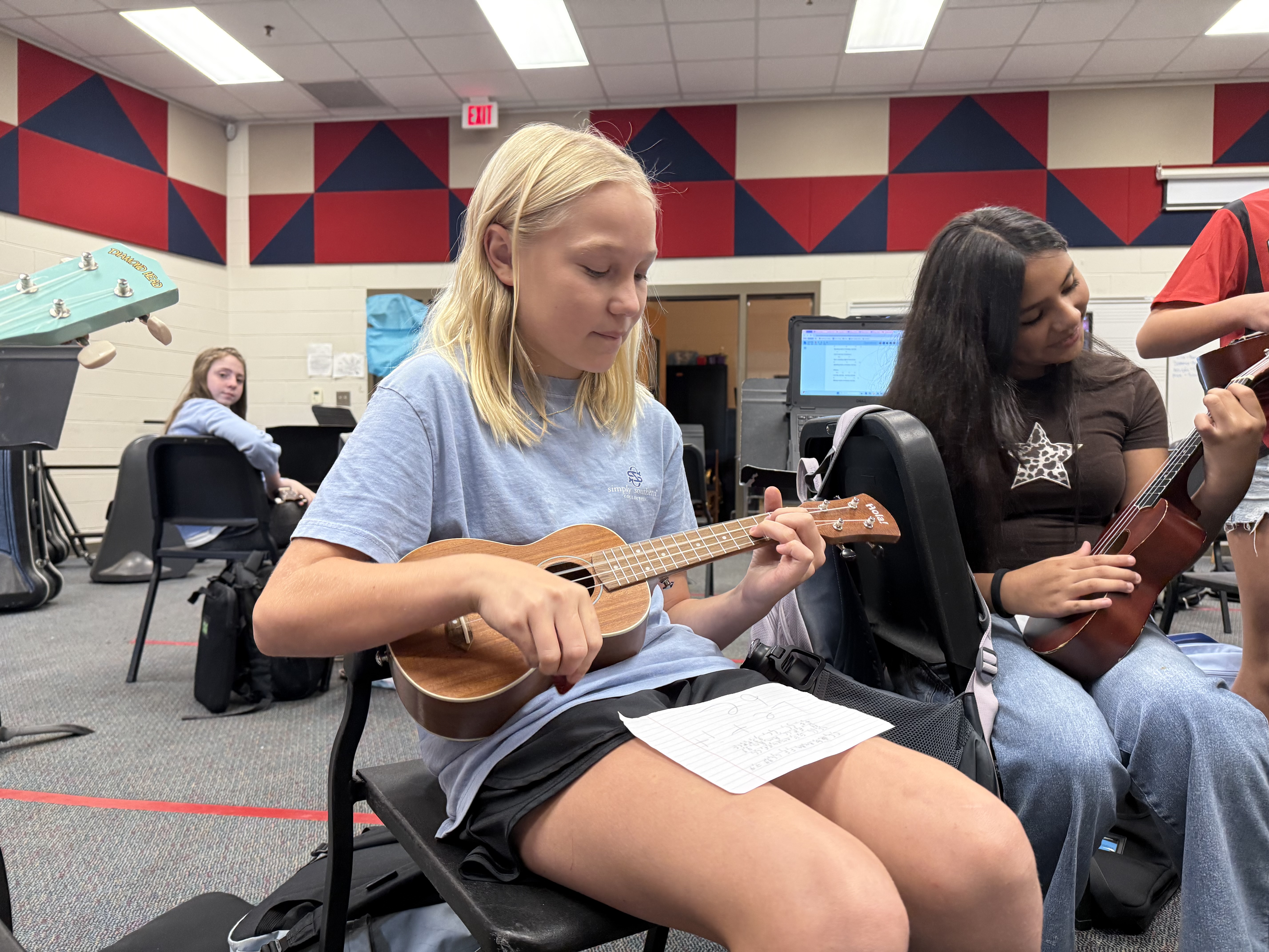 6th-grader Josie Turner holds her ukulele in the OCMS ukulele class. Students use a cheat sheet with lyrics and chords to help them learn the material (Photo/Walker Durham).