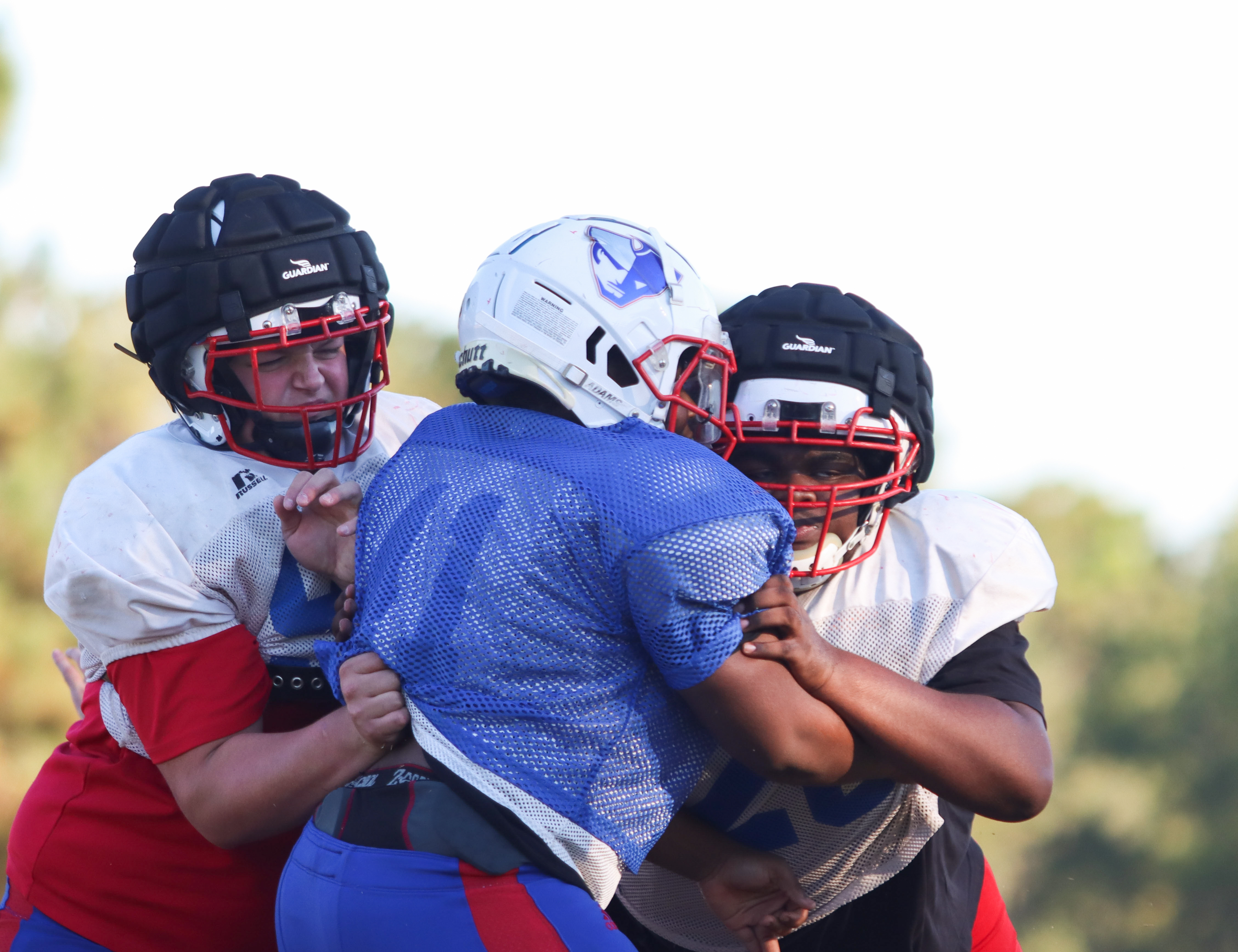 Sophomore Kayden Phelps (left) and junior Isaiah Hood block a teammate during Oglethorpe County football practice earlier this season. Phelps and Hood are wearing Guardian Caps, which have been shown to help prevent concussions. (Sydney Jarrard/The Oglethorpe Echo)