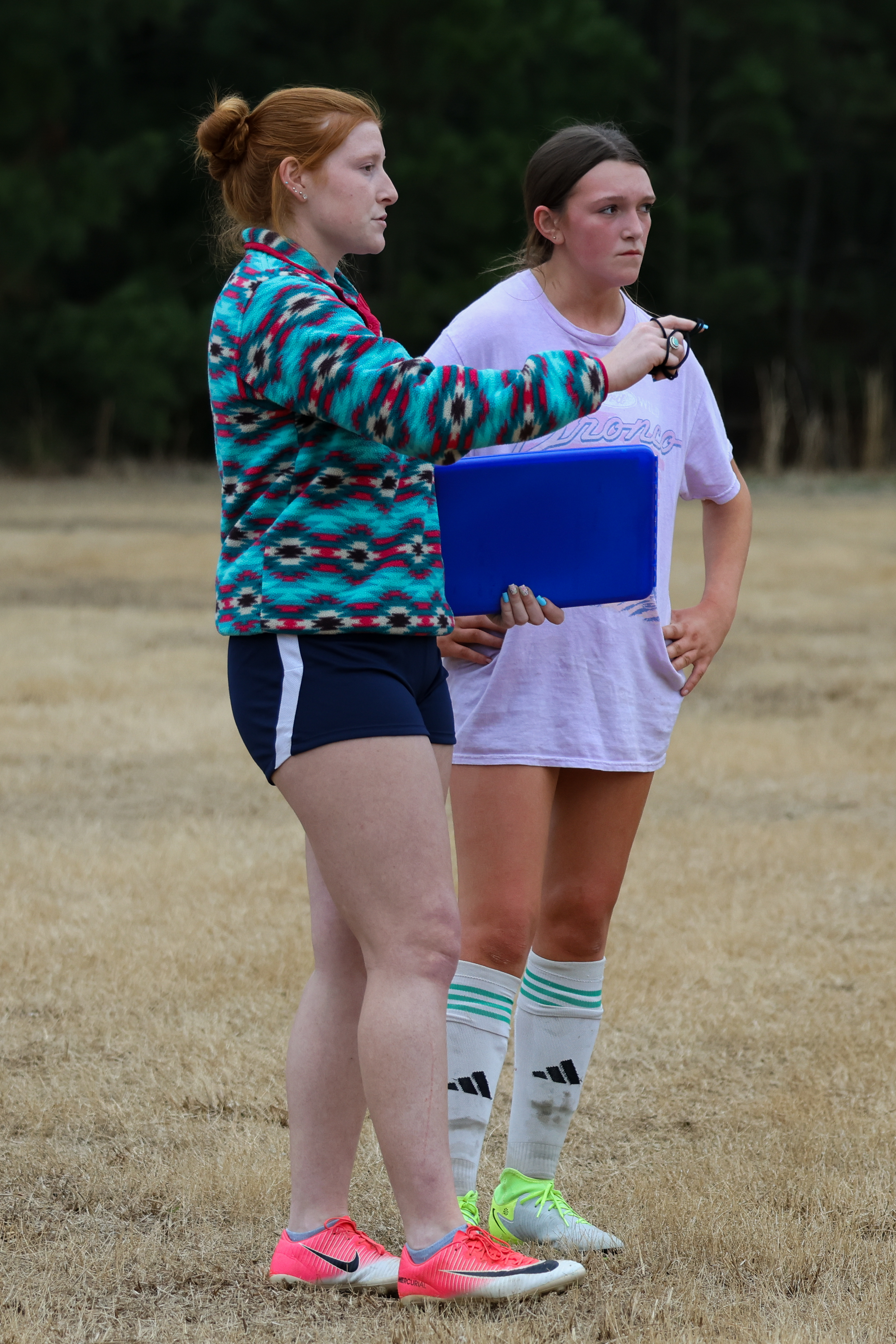 Head coach Madison Nimmons having a one-on-one talk with freshman Cailyn Torbit. Nimmons  encourages her and offering tips on how to improve the little details. (Photo/Addison Simmons) 