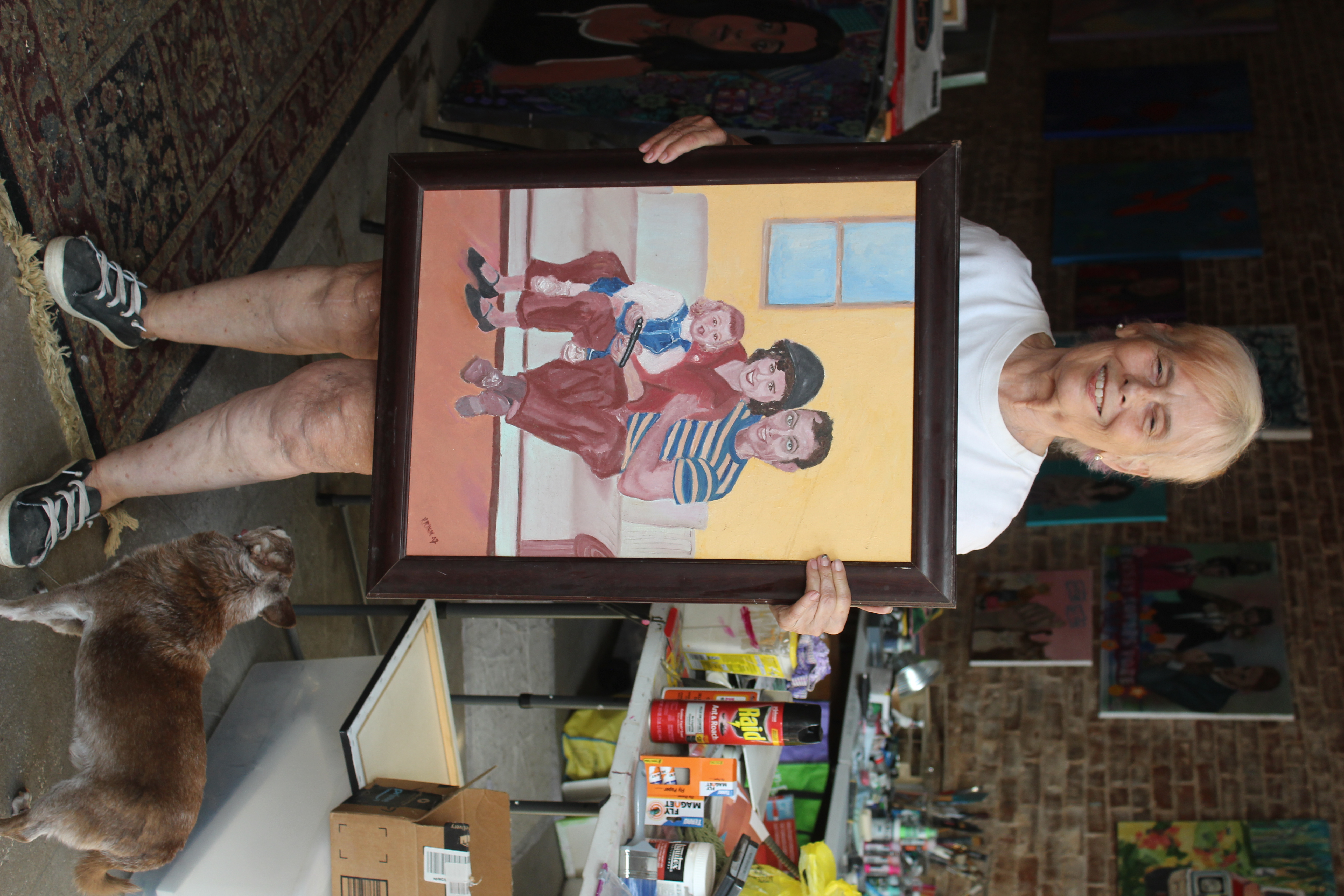 Kristan Ryan poses alongside her dog, Tippy, with a portrait inspired by a photograph of her family when she was child. Ryan grew up in Germany and Morocco before moving to the U.S. at 10 years old. (Hannah Freeman/The Oglethorpe Echo)