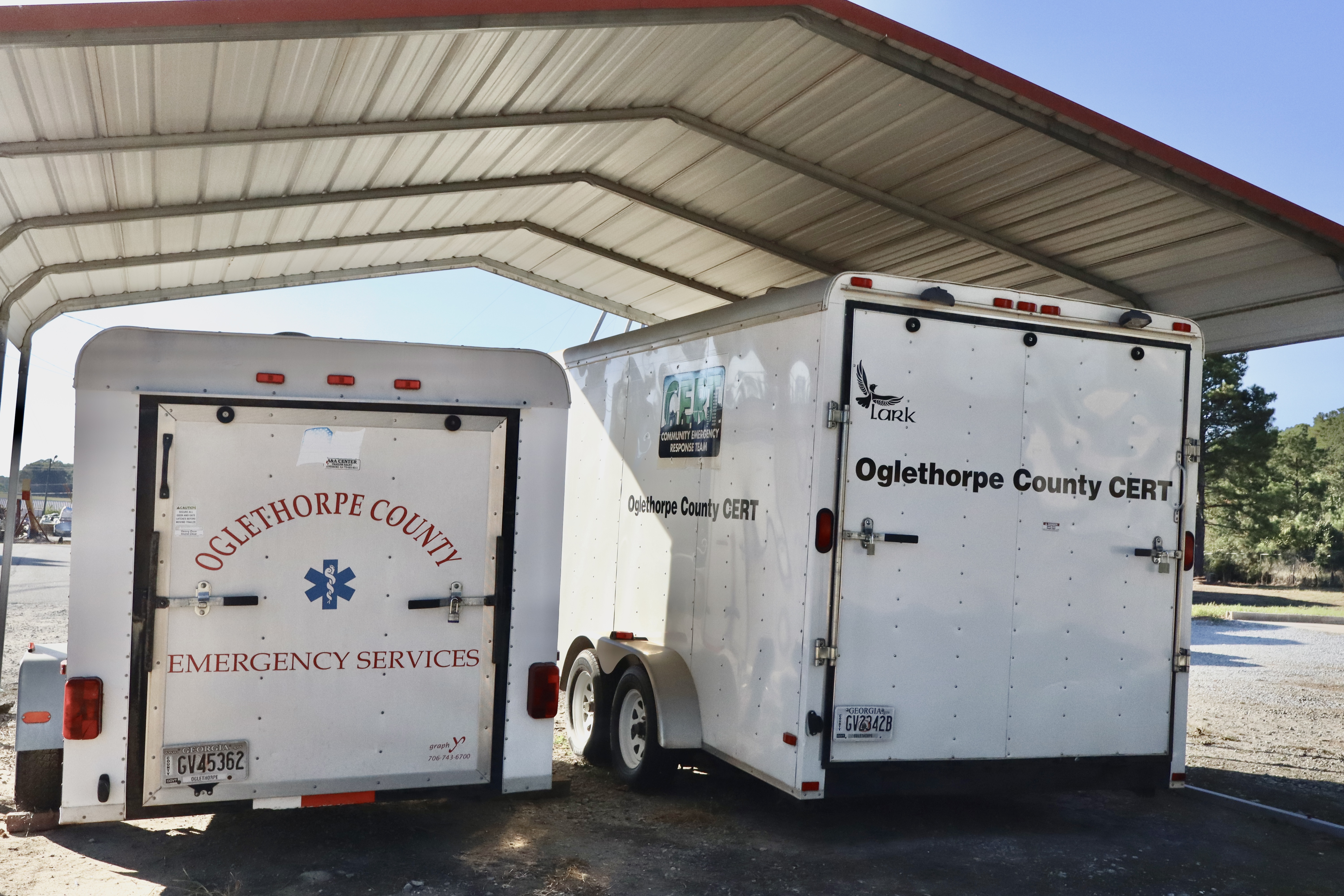 Two EMA trailers sit parked under a covered shelter at the county station. The trailers, housing off-road rescue gear and mobile incident management tools, can now be directly towed by on-duty QRV units. (ISABELLA PANG/THE OGLETHORPE ECHO)