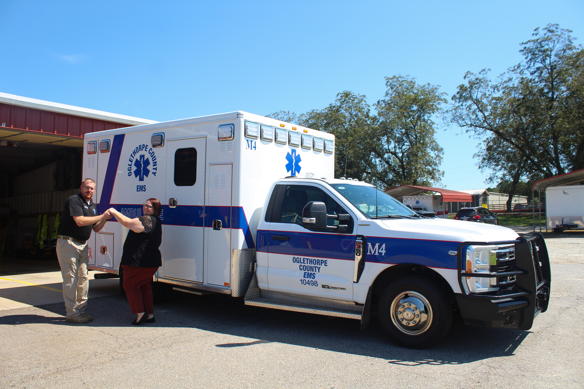 Josh Robinson, Oglethorpe County EMS director, and Kristin Gilliam pose in front of an Oglethorpe County EMS truck on Thursday, Sept. 11, in Crawford, Georgia. The two joked that they were recreating a tacky prom photo and said they love goofing off together. (Photo/Gabrielle Gruszynski)