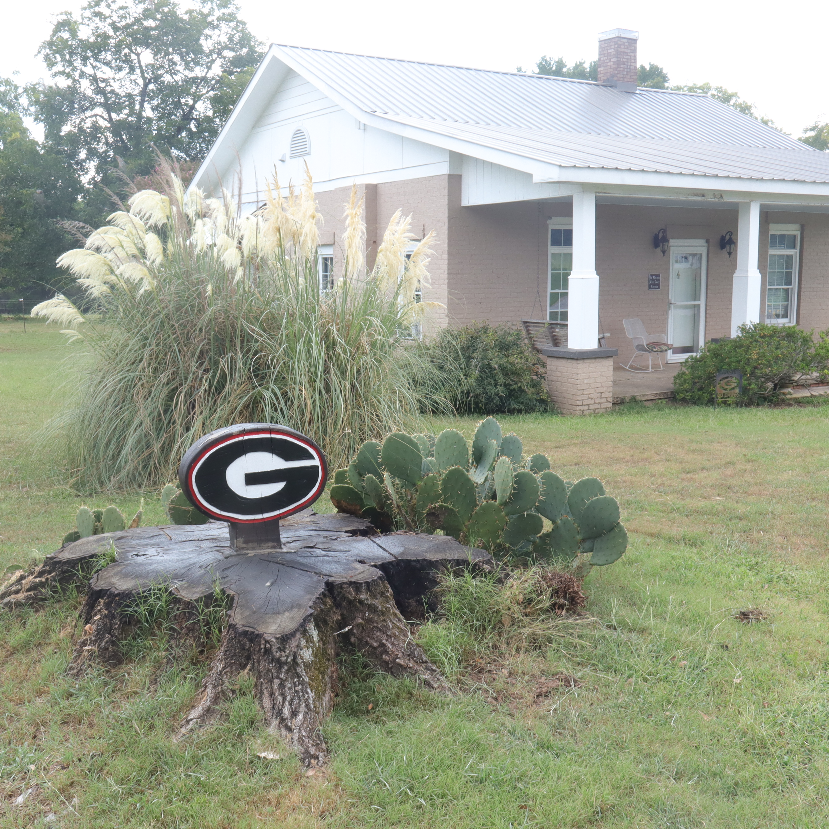 The tree stump topped with the UGA power "G" symbol sits next to the Mitchell Mary Grace cottage renovated by Ken Watson. (Photo/Zaire Rushing-Simpson).