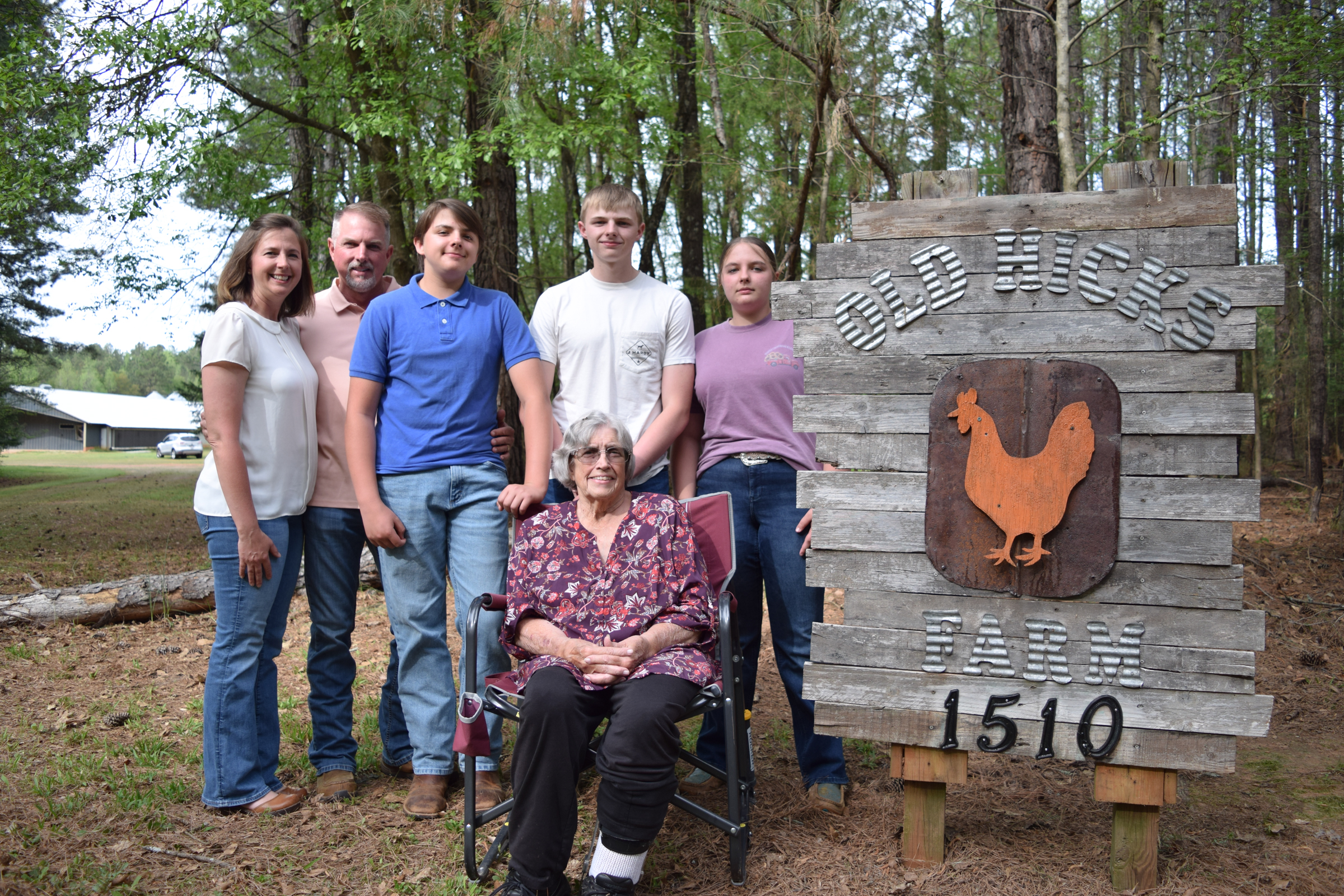 ulie, Jim, JC, Nolan, Brinley and Jan Holloman (left to right) stand next to the sign at the entrance of Old Hicks Farm. The Hollomans own and operate a pullet farm in Crawford, Georgia. (Photo/Jesse Wood)