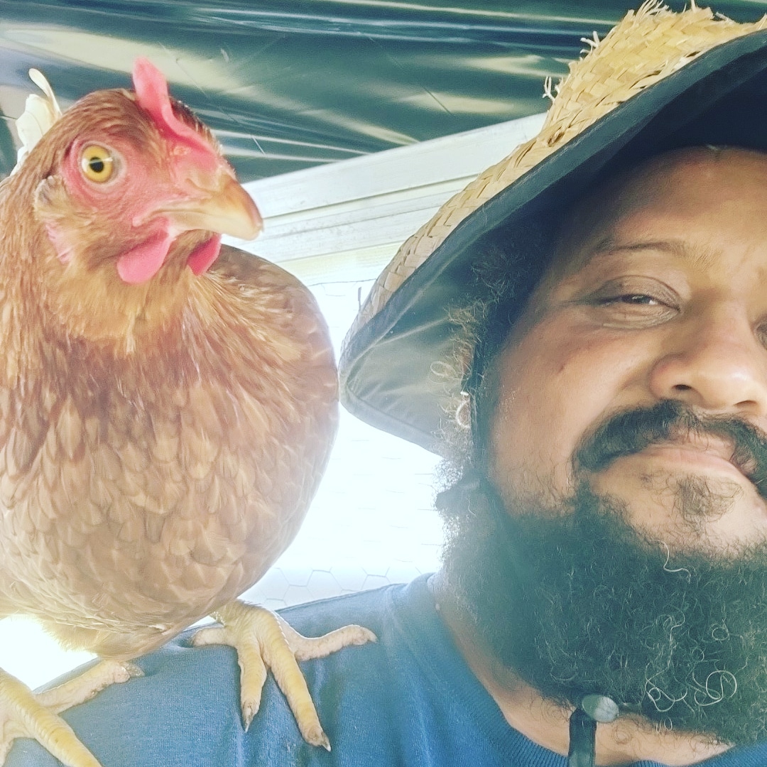 Gabriel Jimenez poses with a chicken at Caribe United Farm. Jimenez has been a co-owner of Caribe United Farm since 2018. (Courtesy/Gabriel Jimenez).
