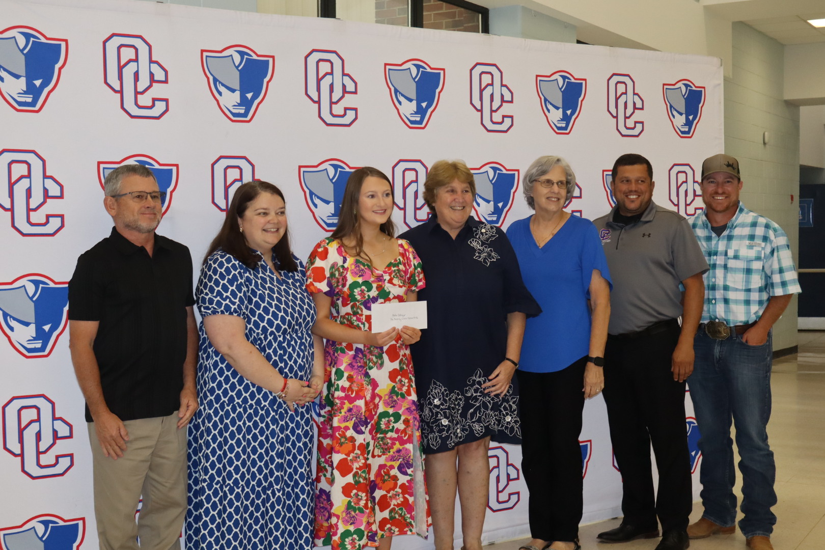 Andee Dellinger stands with her check from the Beverley Levine Patriot Pride Scholarship she was awarded. The BOE stands with her as well as Beverley Levine. (Ellie English/The Oglethorpe Echo)