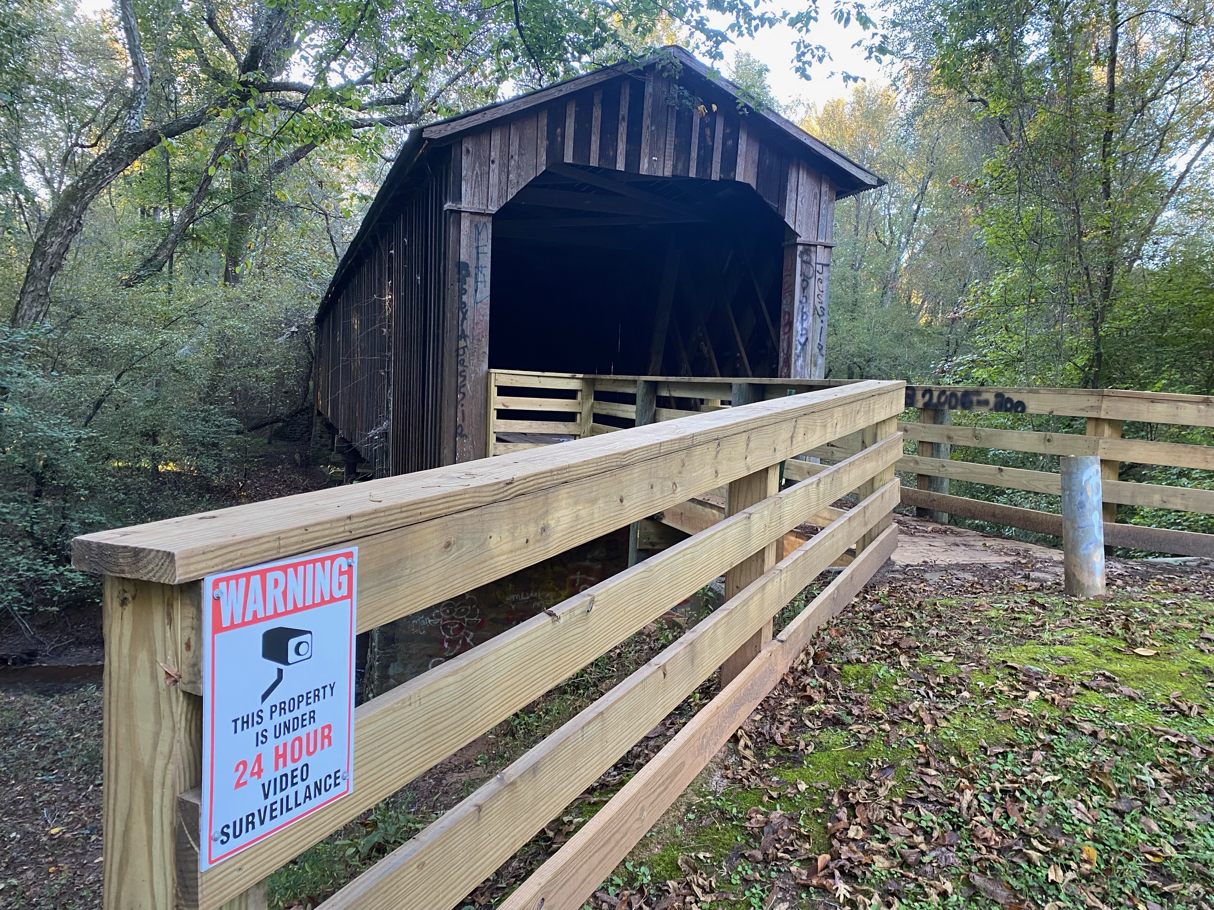 A surveillance sign warns visitors to Howard’s Covered Bridge that cameras have been installed and are being monitored. (Submitted Photo)