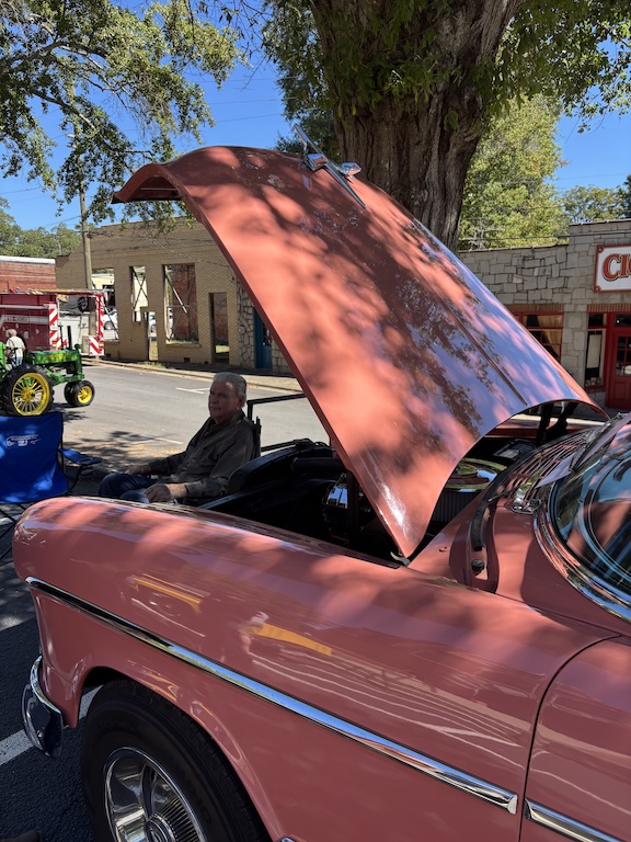 Johnny Smith sits next to his 1955 Chevrolet Bel Air at the Firefly Cruise In on Sunday. Smith said he and his late wife used to attend car shows like this one together. (Maura Potvin/The Oglethorpe Echo)