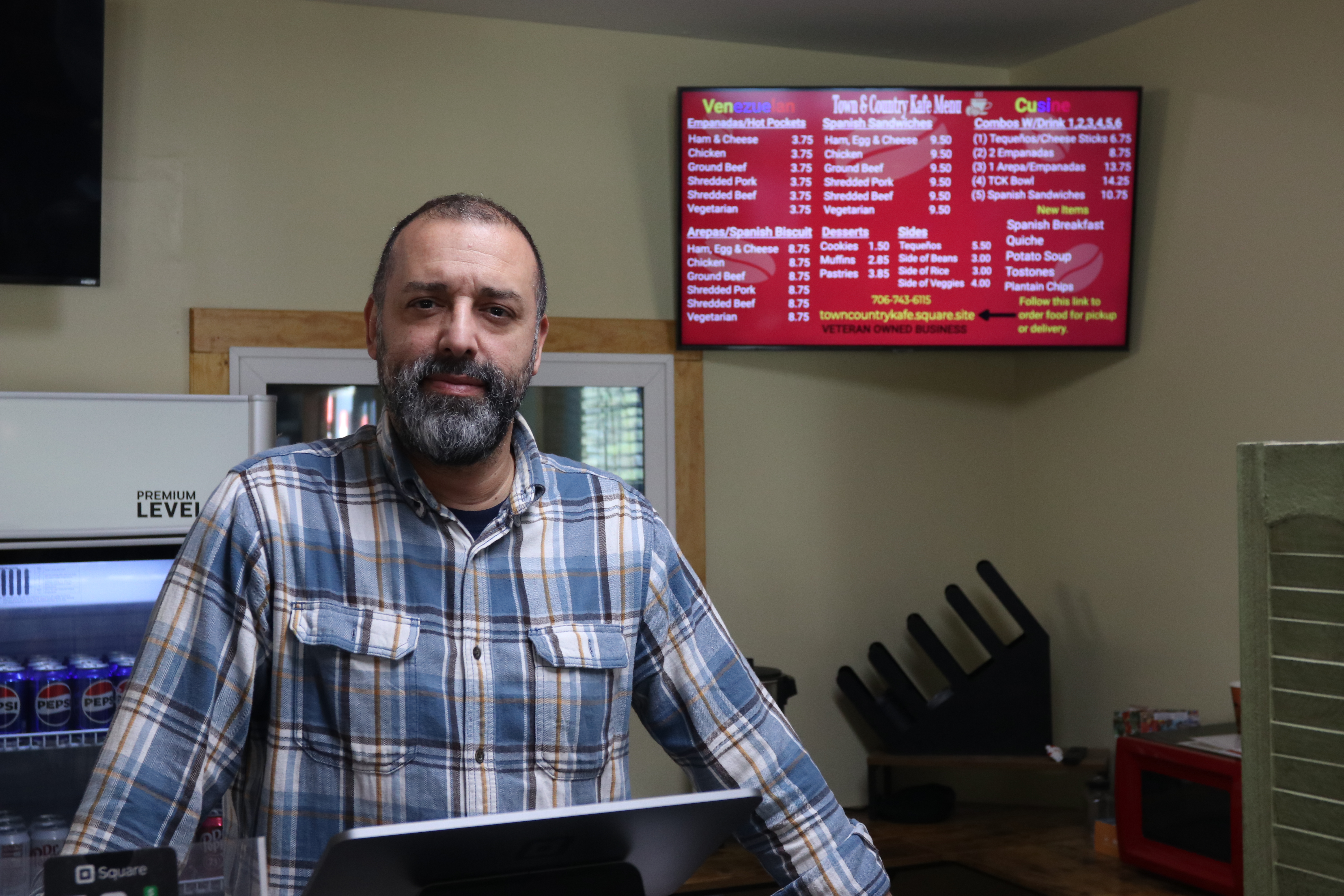 Co-owner Willie Torres stands in at the register in Town and Country Kafe in Crawford, Ga., on Wednesday, Feb. 26, 2025. Torres prioritizes hospitality and community as the barista and cashier, while his wife, Amy Delfin-Torres, works in the kitchen as the chef. (Photo/Adriana Cascio)