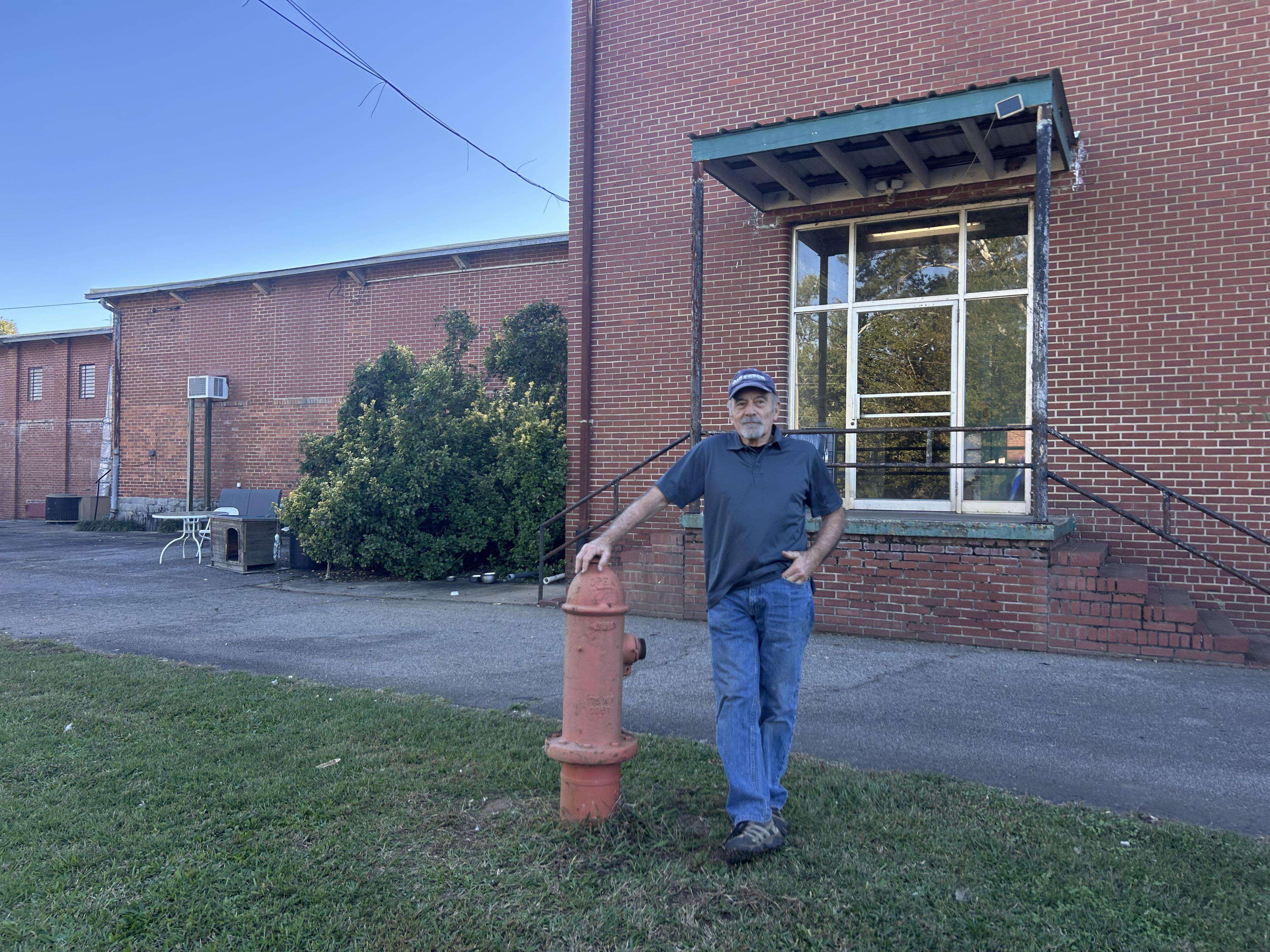 Gary Stacy, the owner of the property, stands for a photo in front of one side of the factory building on Wednesday, October 22, 2025. Stacy hopes the new owners will cherish the property like he has. (Makenna Reavis/The Oglethorpe Echo)