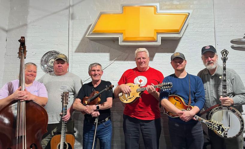 Deirdre Smith, John Smith, Robert Hauth, Dennis Helmreich, Robert Smith and Mike Harrison pose at G Brand BBQ  in Crawford. The bluegrass group hosts “jam sessions” at the restaurant every Thursday night. (Shannon Moran/Oglethorpe Echo)