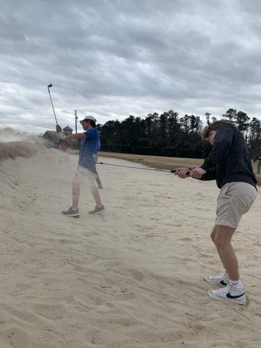 The boys golf team practices hitting out of the sand. (Meredith Boyd/The Oglethorpe Echo)
