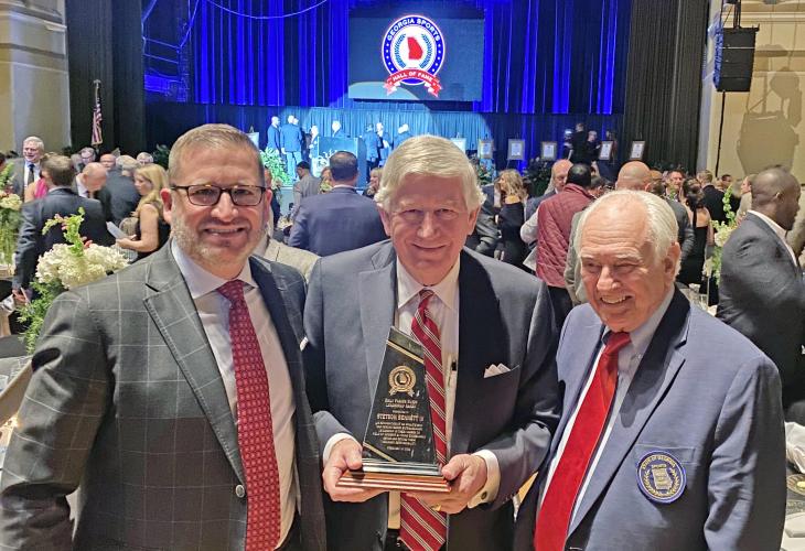 UGA athletic director Josh Brooks (left) and UGA’s Loran Smith flank Dink NeSmith as he displays Stetson Bennett’s leadership award received at the Georgia Sports Hall of Fame banquet on Feb. 19 in Macon. (Jennifer Smith/Submitted Photo)