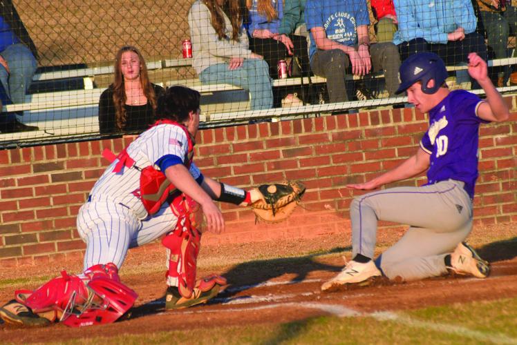 Senior catcher Jonathan Cronic puts the tag on a Richmond Academy runner in the Patriots’ 14-4 season-opening win on Tuesday. (Ralph Maxwell/Submitted Photo)