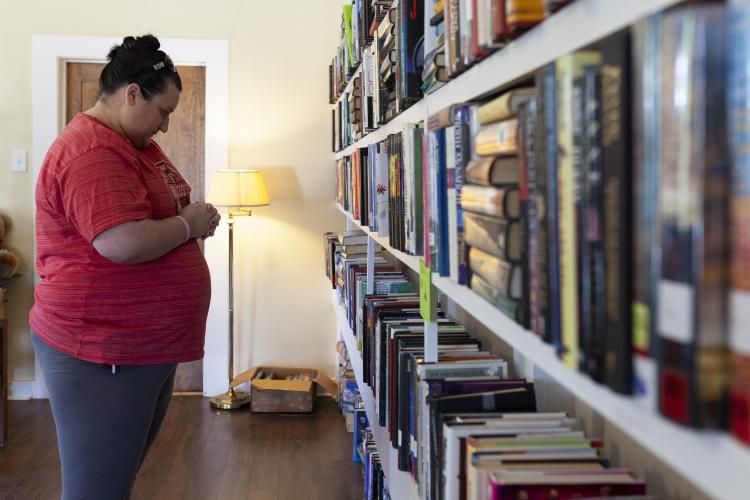 A patron browses the hardcover shelves at the Seed Swap and One-Day Book Sale at No. 3 Railroad Street on Saturday. This was the first time that a seed swap accompanied the book sale. (Sydney Fordice/The Oglethorpe Echo)