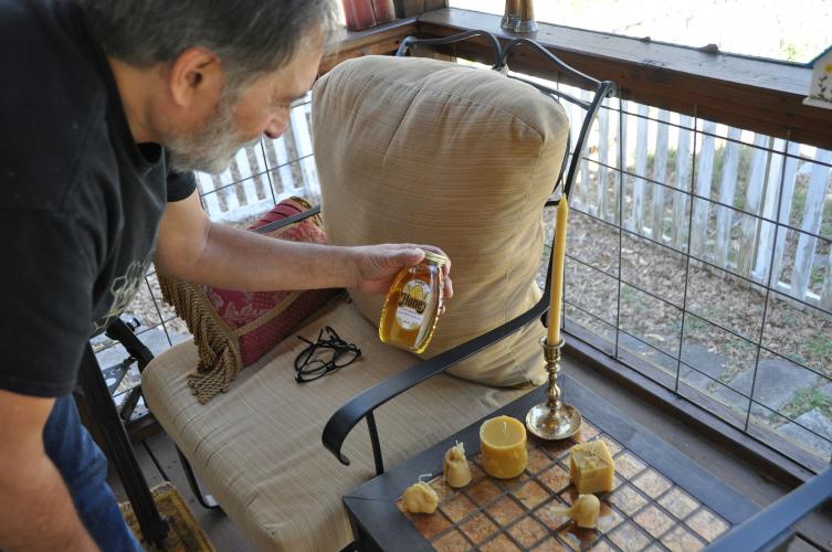 Joe Conti shows his homemade honey and beeswax candles, which he sells on the Oglethorpe County Bee Club’s website and at festival booths. (Elena Westbury/The Oglethorpe Echo)