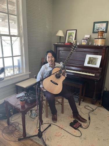 Hiroya Tsukamoto performs with his guitar. Originally from Kyoto,  Japan, his performance is a fusion of jazz, folk and world music. (Sabrina Laster/The Oglethorpe Echo)