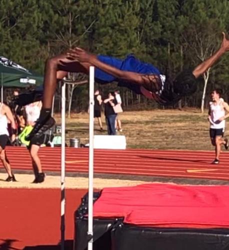 Kenzie Henderson leaps over the bar to set a school and region record of 5 feet, 6 inches in the high jump at the season-opening meet on March 3. (Submitted Photo)