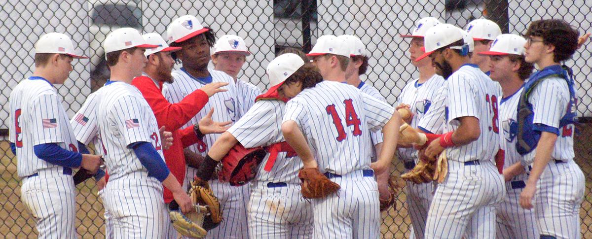 Baseball coach Kris Patel (in jacket) meets with his team during its 6-5 win over Westside. (Ralph Maxwell/The Oglethorpe Echo)