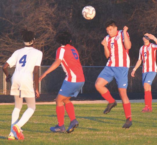 Armando Padilla (No. 7) heads the ball above teammate Eric Lopez-Salazar (No. 6) and a Richmond County Technical Career Magnet School in the Patriots' 9-0 win on Feb. 25. (Ralph Maxwell/ Submitted Photo)