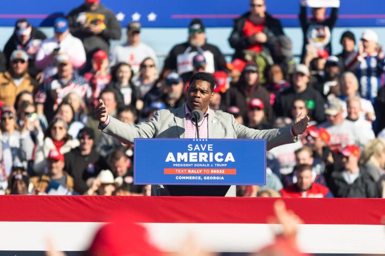 Former Georgia running back Herschel Walker speaks at a Save America rally. Walker is a member of the 1980 Georgia Bulldogs football team that won the National Championship, and is currently a primary contender for the U.S. Senate looking to unseat incumbent Democratic senator Raphael Warnock. Walker spoke briefly on a range of topics. During his remarks he highlighted his opposition to allowing transgender athletes. (Julian Alexander/For The Oglethorpe Echo)