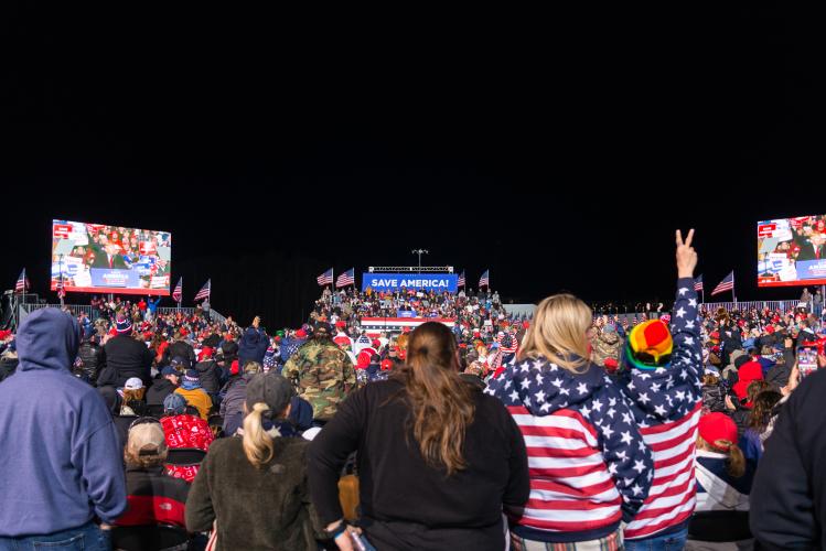 Attendees listen to former President Donald Trump at a Save America rally at the Atlanta Dragway on Saturday, March 26, 2022 in Commerce, Georgia. The crowd was far smaller in reality than initially estimated, coming in around five thousand. It was anticipated to be twenty thousand people. Pictured is the seated area from the media area at the back. There were large blocks of attendees adjacent to either side of the media risers, behind the seated area.(Julian Alexander/For The Oglethorpe Echo)