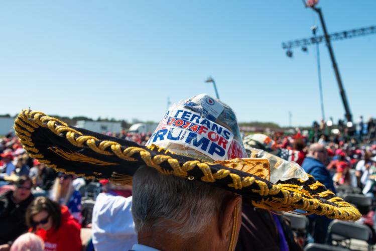 James Yates, the “Sombrero Trump”, stands amongst the crowd at a Save America rally at the Atlanta Dragway on Saturday, March 26, 2022 in Commerce, Georgia. Yates’ sombrero features stickers on the top and front bill of the hat. Many supporters wore custom headgear and costumes in support of the former President. (Julian Alexander/For The Oglethorpe Echo)