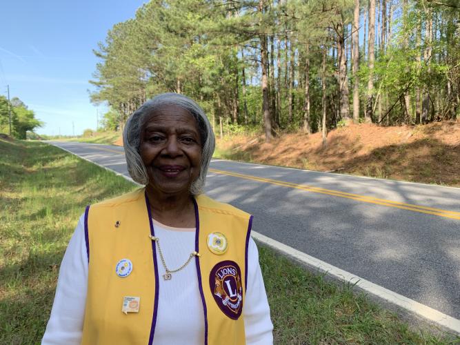 Eleanor Edwards smiles on Buddy Faust Road, during a recent mid-morning clean up. She's been walking and cleaning the 2-mile stretch for nearly 20 years. (Photo/Katherine Lewis)
