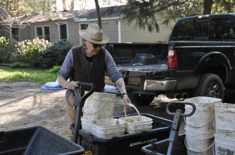 Kat Howkins, co-founder of Sweet Olive Farm, fills her truck and wagons with food buckets to take across the street to the farm. Sweet Olive Farm was founded in 2010 and became a non-profit organization in 2015. (Elena Westbury/The Oglethorpe Echo)