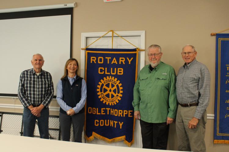 Oglethorpe County Rotary Club founding charter members pose with current president Susan Sharp in front of the chapter’s flag. Roger Neesmith (from left), Sharp, John Stephens and Bill Cabaniss are pictured. (ELOISE MCNAIR/THE OGLETHORPE ECHO