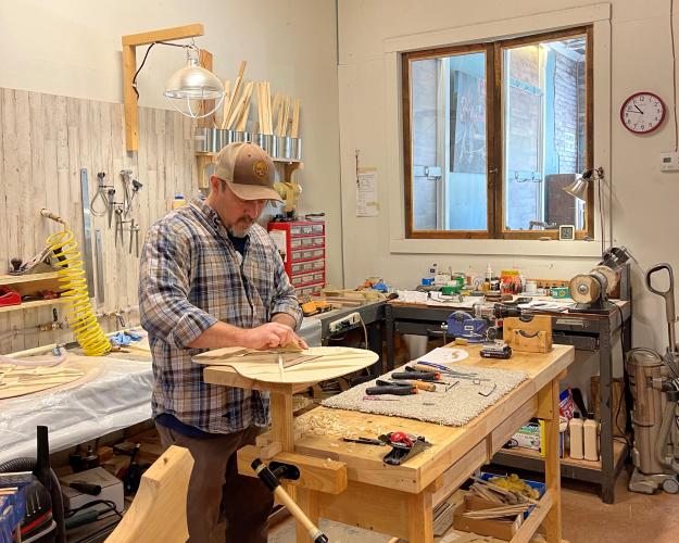 Owner Jason Booth works on a guitar for a customer. Booth says it takes around 30 hours to build a guitar from start to finish. (Photo/Colt Yeargin)