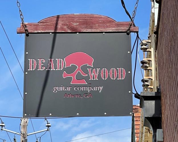 The Deadwood Guitar Co. sign hangs along the storefront in downtown Lexington, where the shop has been for the last six years. Owner Jason Booth decided to move his storefront from Athens to Lexington to be closer to home. (Photo/Colt Yeargin)