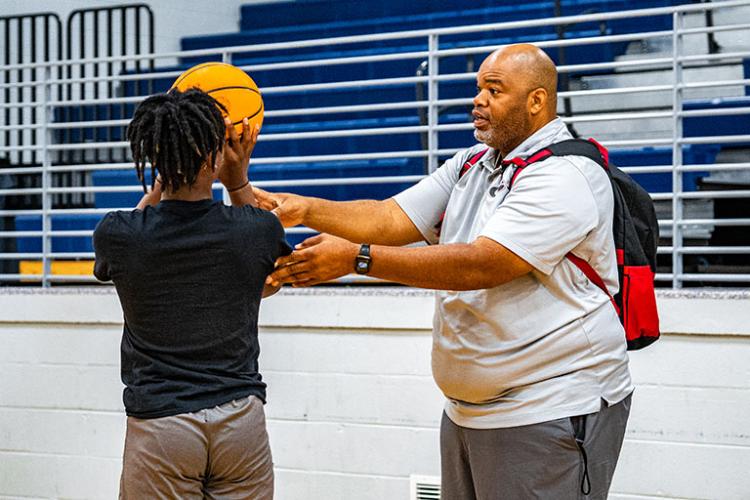 OCHS boys basketball coach Larry Brown gives shooting tips to a camper during his first camp since being hired last year. Brown will have another session, which is scheduled from July 11-15. (Photo/Jack Casey)