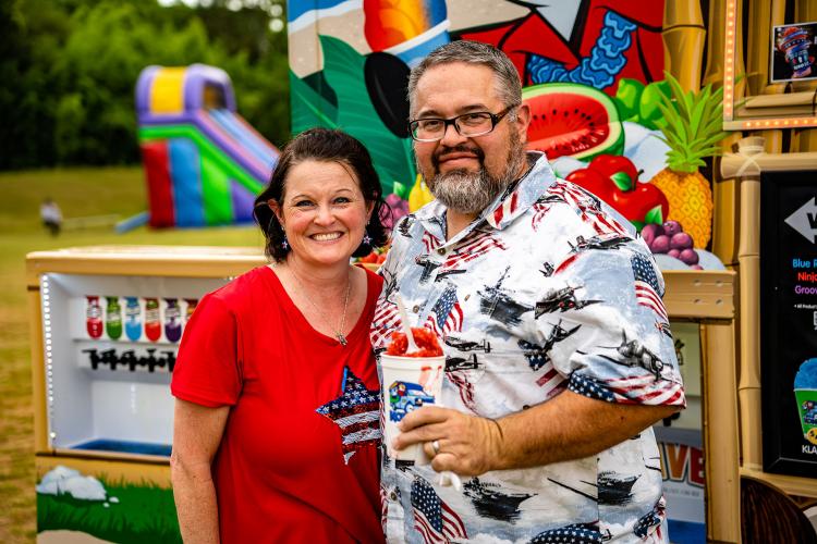 Wendy and Brent Zellner of Crawford try to keep cool with a cup of shaved ice from the Kona Ice truck on Monday. (Photo/Jack Casey)