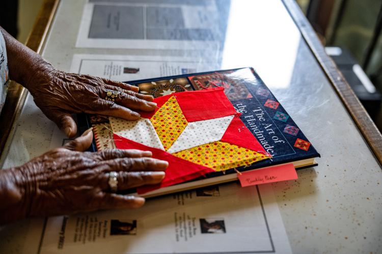 Beatrice Brown shows off a pattern of a quilt she's started. Her hands also paint barn quilts, used to decorate the sides of buildings. (Jack Casey/The Oglethorpe Echo)