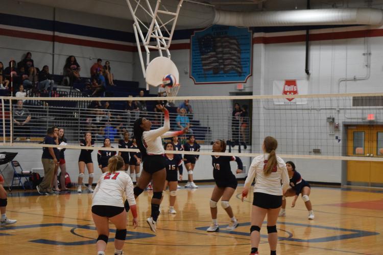 Tania Latimore (10) makes a play at the net as Sofia Horsley and Samantha Amos (28) provide support in the 3-0 victory over Putnam County. (Photo/Jack Casey)