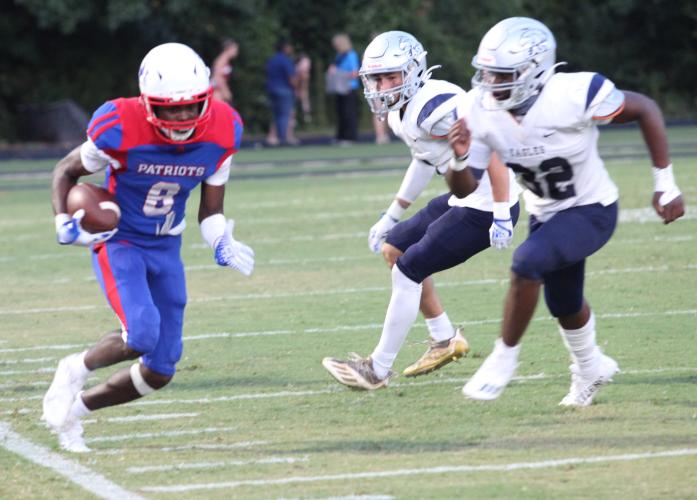 Darius Heard tiptoes up the sideline for yardage as East Jackson defenders close in on him in the Patriots’ victory. He led the Patriots with four receptions for 40 yards. (Photo/Donny Faust)