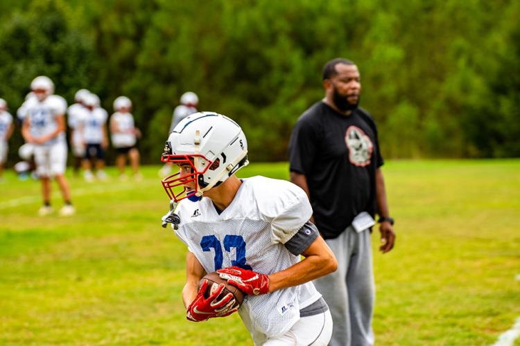 Senior Brady Allgood turns upfield with the ball as the OCHS football team goes through drills earlier this week. (Photo/ Jack Casey)